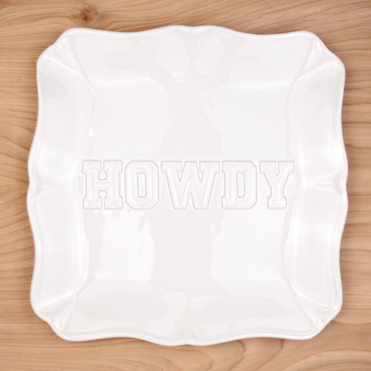 White platter with 'HOWDY' text on a wooden surface