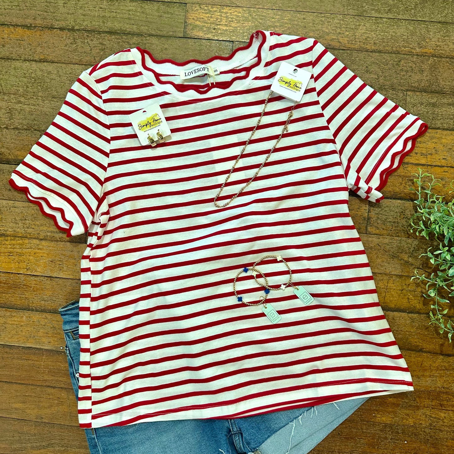 Red and white striped shirt with tags on a wooden surface