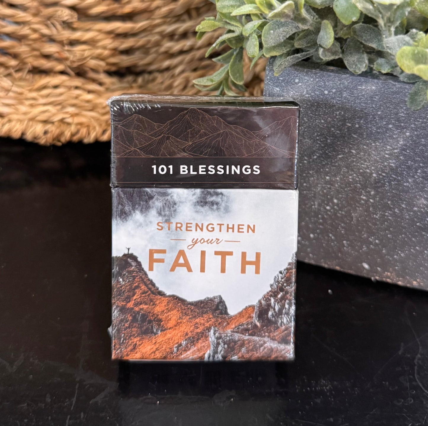 Pack of '101 Blessings' cards with nature-themed design on a dark surface with a plant in the background.