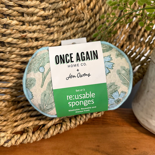 Set of reusable sponges with a label on a woven surface