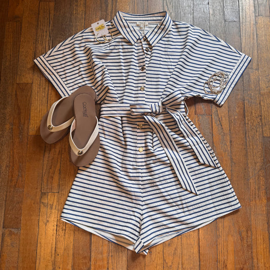 Striped romper with sandals on a wooden floor