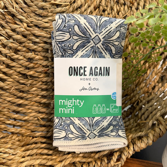 Folded fabric with 'Once Again Home Co.' packaging on a woven surface