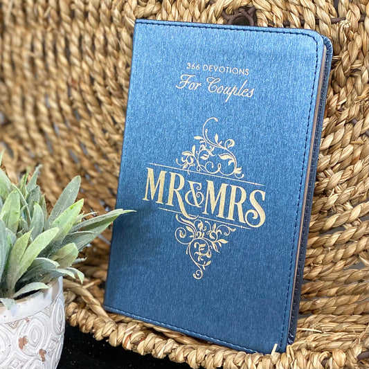 Blue book titled 'Mr & Mrs' with decorative text on a woven surface