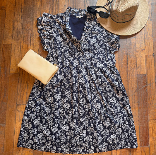 Floral dress with a hat and clutch on a wooden floor