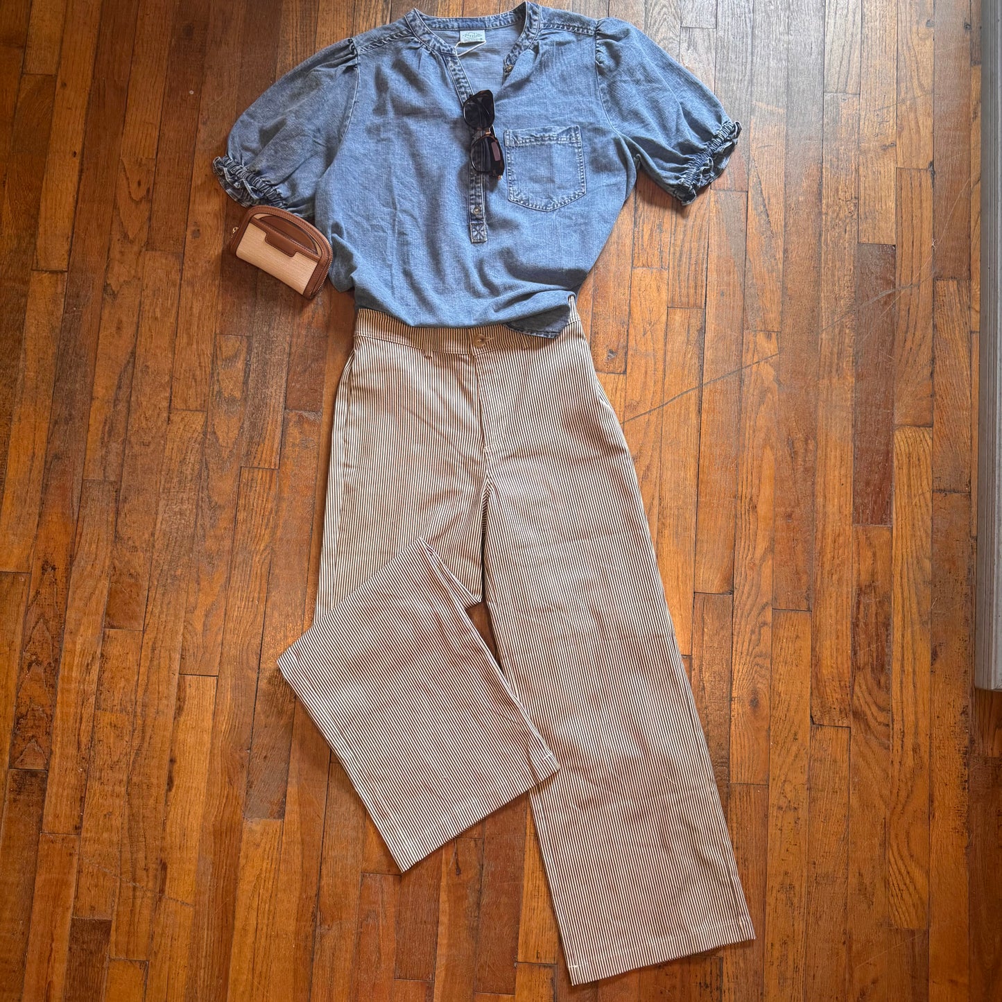 Blue shirt and brown pants laid out on a wooden floor