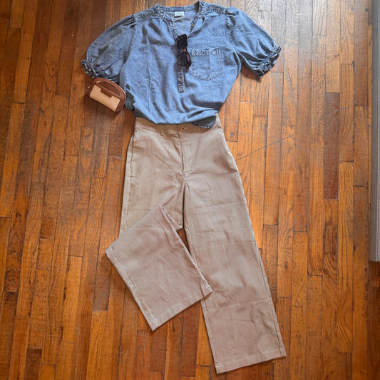 Blue shirt and brown pants laid out on a wooden floor