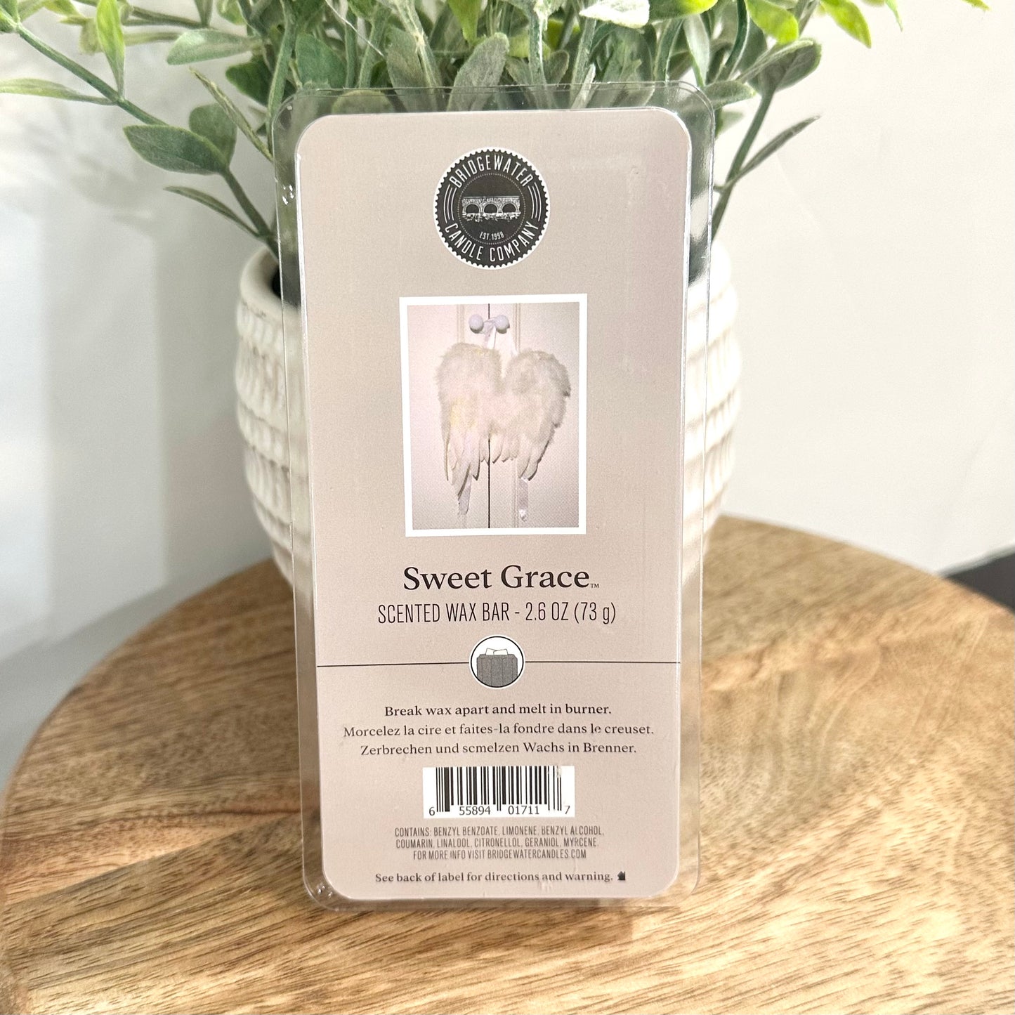Scented wax bar packaging labeled 'Sweet Grace' on a wooden surface with a plant in the background.