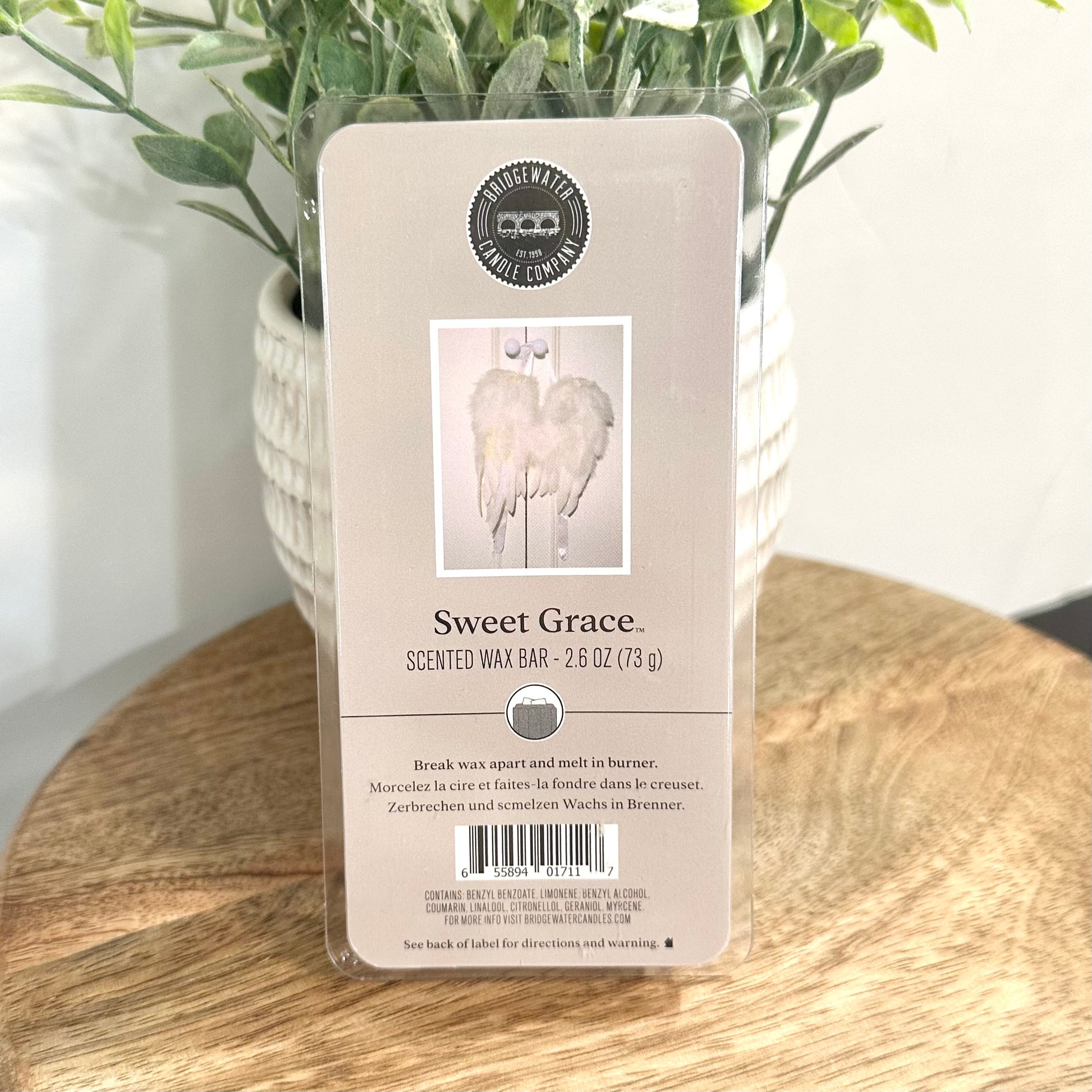 Scented wax bar packaging labeled 'Sweet Grace' on a wooden surface with a plant in the background.