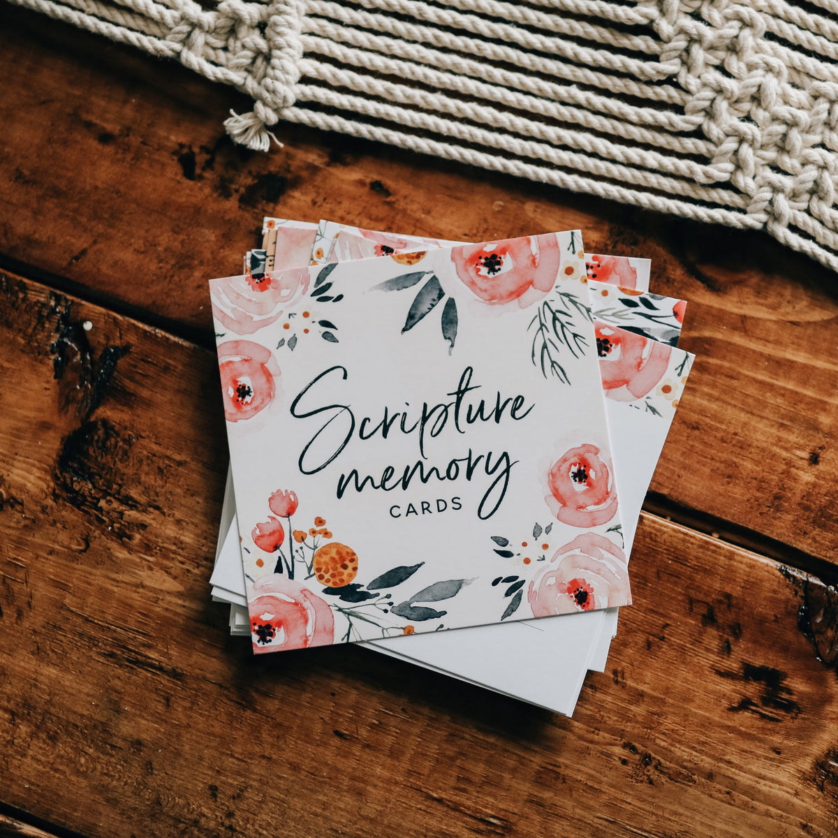 Stack of 'Scripture memory cards' with floral design on a wooden surface