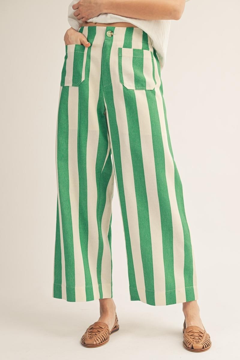Green and white striped pants worn by a person on a plain background