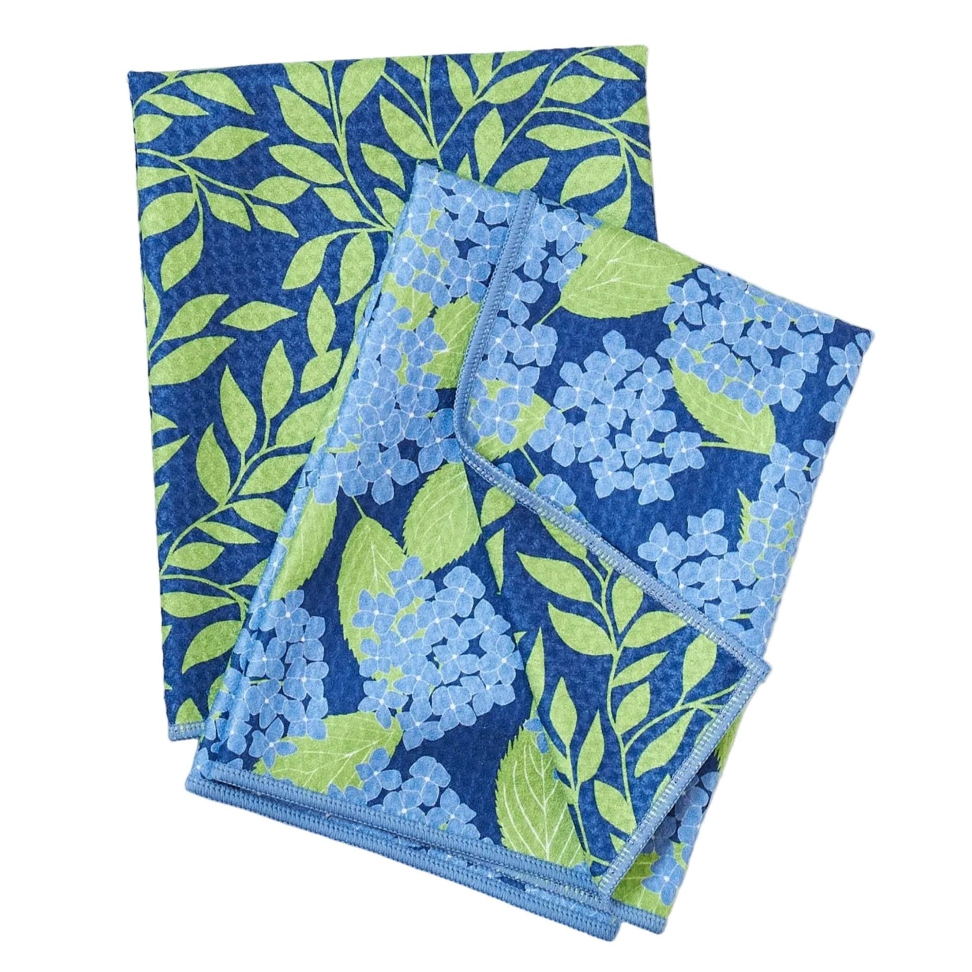 Two blue and green patterned towels on a white background