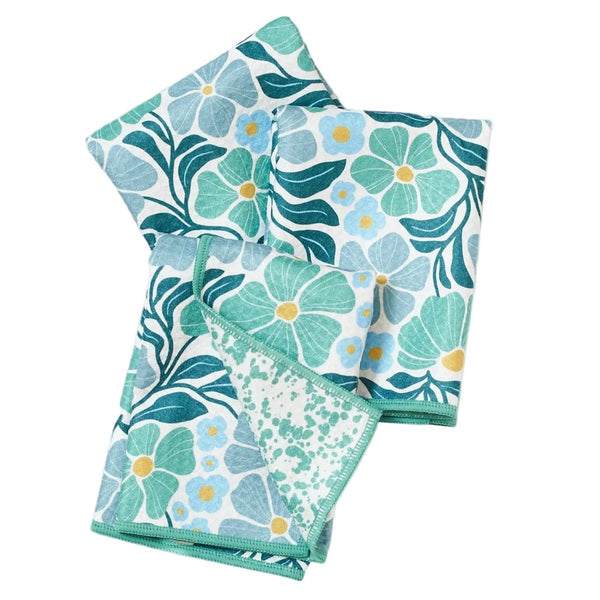 Set of three floral-patterned towels in green and blue on a white background